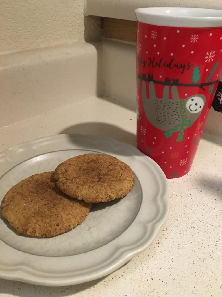 Plate of cookies next to a mug with a sloth on it