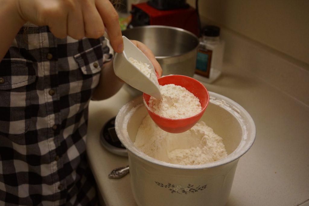 Flour being scooped into a measuring cup