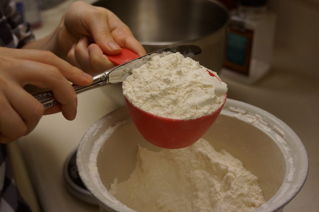 Flour being leveled off with a knife