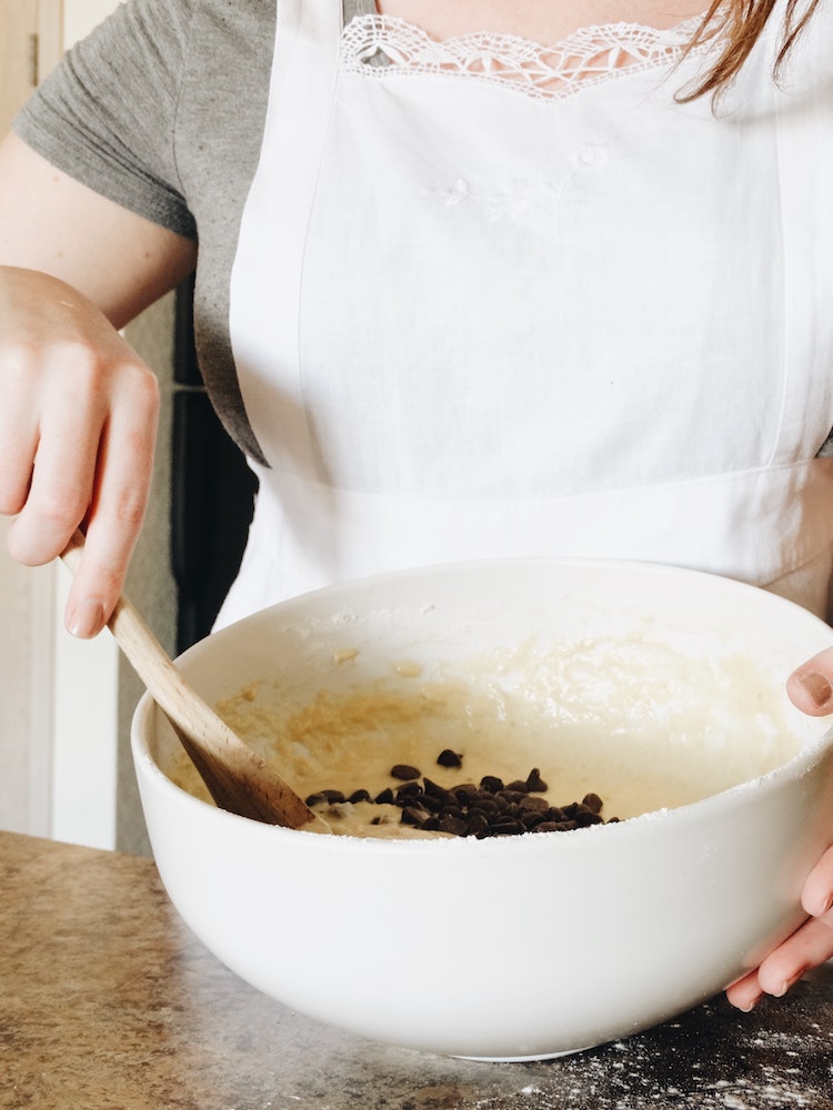 Person stirring bowl of cookie dough